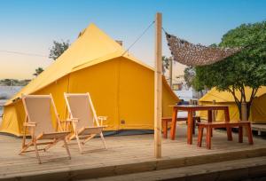 法鲁Glamping Camp Faro的帐篷前配有椅子和桌子