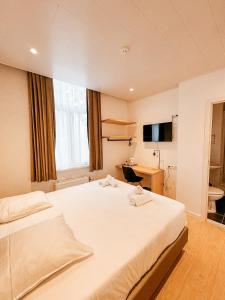 奥斯坦德阿尔法酒店的卧室配有一张白色大床和一张书桌