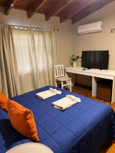 里奥夸尔托花园洋房饭店的一间卧室配有蓝色的床和毛巾