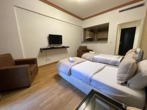 贝鲁特Elegant Suites Beirut的酒店客房设有两张床和一台平面电视。