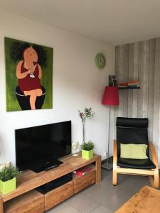 卡斯特里科姆Fewo Klimduin Castricum的客厅配有平面电视和椅子。