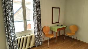 DallenwilPilgerhaus Maria-Rickenbach的一间设有两把椅子、一张桌子和一个窗户的房间