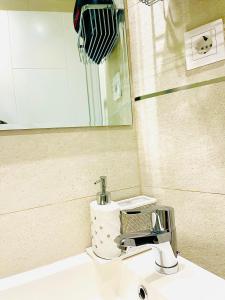 马德里MADRID CENTRO的浴室水槽设有水龙头和镜子