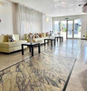 里米尼Hotel B&B Ardea Rimini的一间客厅,客厅内配有一张沙发和一张桌子,位于大理石地板。