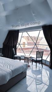 瓦迪拉姆Rum Skye camp的一间卧室配有一张床、两把椅子和一个窗户