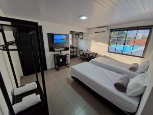 伊瓜苏Condomínio Inn The Studio的一间卧室配有一张床和一台平面电视