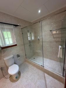 拉迪格岛Benjamine's Guesthouse的一间带卫生间和玻璃淋浴间的浴室