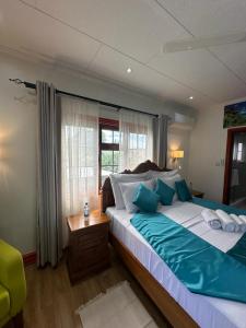 拉迪格岛Benjamine's Guesthouse的一间卧室设有一张大床和一个窗户。
