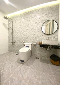头顿VND Vũng Tàu Hotel & Villa的一间带卫生间、水槽和镜子的浴室