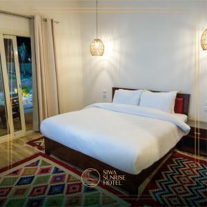 锡瓦Siwa Sunrise Hotel的一间卧室配有一张带白色床单的大床