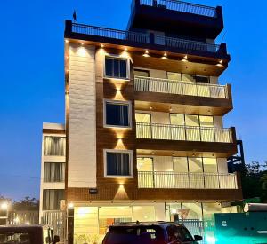 大诺伊达Raksha Suites & Banquet Greater Noida的一座高大的建筑,旁边灯火通明