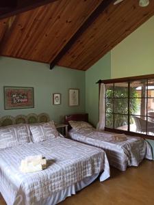 卡瓦坎特Chalés Pássaros do Cerrado的一间卧室设有两张床和窗户。
