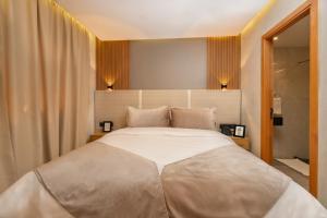 马拉喀什Appart Hôtel Rambla的一间卧室配有一张带两盏灯的大型白色床。