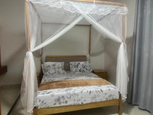 莫罗戈罗Winnie's Home的卧室内的一张带天蓬的床