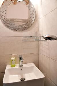 爱琴娜岛卡洛肯提公寓的浴室设有白色水槽和镜子