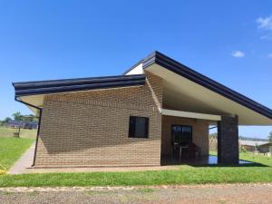 HohenauModernes Ferienhaus in Paraguay, Hohenau mit Reitanlage und Beachvolleyball的一间黑色屋顶的小砖屋