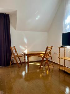 索非亚En-Suite Rooms: Novа Guesthouse in Sofia Center的一间带木桌和两把椅子的用餐室