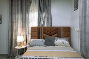 KasoaCMP APARTMENTS的卧室内的一张带木制床头板的床