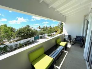 辛普森湾New* Tropical Modern Townhouse in SXM的阳台配有两把绿色椅子和窗户