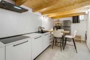 卡利亚里New 2024 Urban 48的厨房配有白色橱柜和木制天花板
