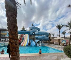 赫尔格达شاليه داخل ميراج اكوا بارك的度假村游泳池的水滑梯