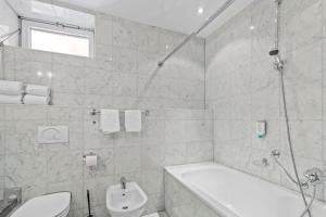 维也纳希尔德酒店的带浴缸、卫生间和盥洗盆的浴室