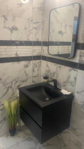 VratsaХотел Враца的浴室设有黑色水槽和镜子