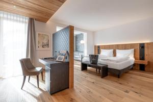 阿罗萨Waldhotel Arosa的酒店客房配有一张床、一张桌子和一把椅子。