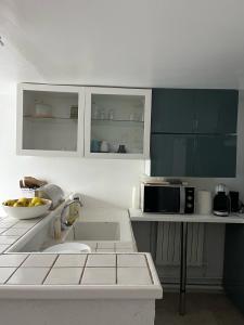 BlaruLa petite campagne的厨房配有白色橱柜和微波炉