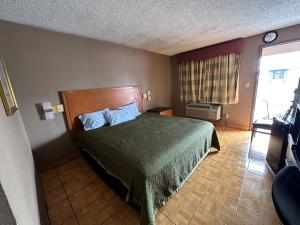 哈灵根Lone Star Inn & Suites的一间卧室配有一张带绿床罩的床