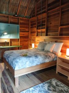 圣玛尔塔Casa Sol Y Sombra的一间卧室设有一张床和木墙