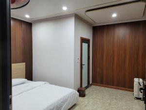 Ban Hin LomKhu nghỉ dưỡng GOOD TIME的卧室配有白色的床和木墙