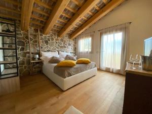 Cinto EuganeoAZIENDA AGRICOLA CA' LUNGA的一间卧室设有一张床和石墙