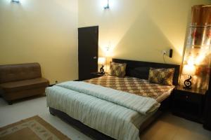 卡拉奇Seasons Inn的一间卧室配有一张大床和一把椅子