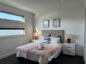 North ShoreGeelong Luxury Beach K Villa的一间卧室设有一张大床和一个窗户。