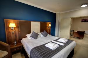 滨海绍森德罗奇福德酒店的一间卧室配有一张大床和毛巾