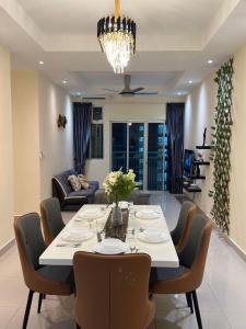Kampong Kuala MasaiMeridin Bayvue 3 Bedroom的用餐室以及带桌椅的起居室。