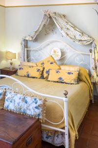科尔托纳洛坎达莫利诺酒店的白色的床,配有黄色和蓝色的枕头