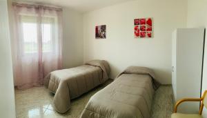 布林迪西A casa di Zia Ale的一间卧室设有两张床和窗户。