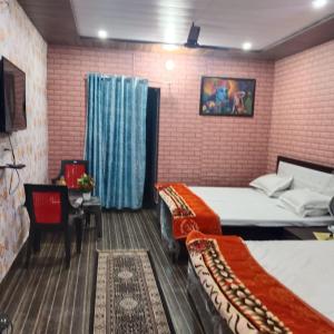 范兰德凡Somnath residency radhe nikunj的一间带两张床的卧室和一台电视