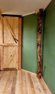 泽尔赫姆Gastenhuisje的一间拥有绿色墙壁、一扇门和一棵树的房间