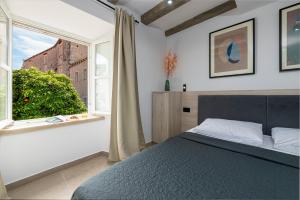 杜布罗夫尼克Sounds of Ragusa的一间卧室设有一张床和一个窗口