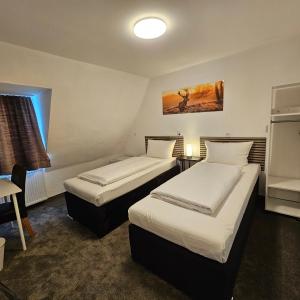 鲁尔河畔米尔海姆科隆霍夫酒店的酒店客房设有两张床和一张桌子。