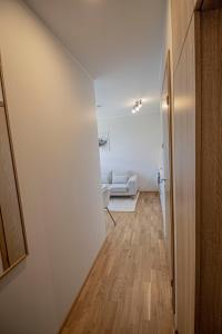 塔尔图Express Premium apartments - city center的走廊上设有白色墙壁和木地板的房间