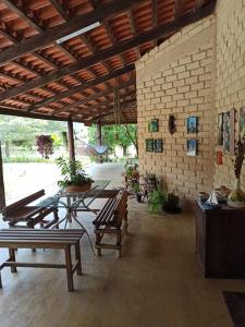 卡瓦坎特Chalés Pássaros do Cerrado的一个带桌子、长椅和砖墙的庭院