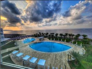 吉布提Gadileh Resort Hotel的享有带椅子的游泳池和大海的景色