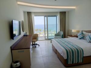 吉布提Gadileh Resort Hotel的酒店客房配有一张床和一张书桌及一台电视