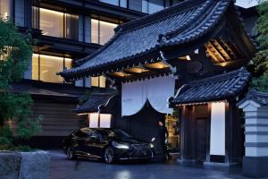 京都HOTEL THE MITSUI KYOTO, a Luxury Collection Hotel & Spa的停在大楼前的一辆黑色汽车
