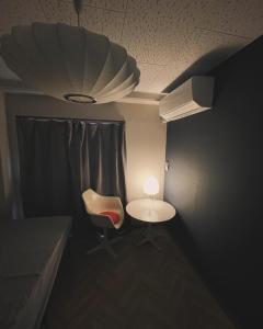 SaikiHostel UND BASE的配有桌子、椅子和灯的房间