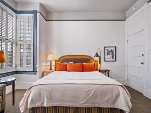 圣巴巴拉阿珀姆酒店的一间卧室配有一张带橙色枕头的大床